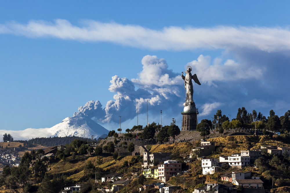 Cotopaxi volcano provides a stunning backdrop to Panecillo’s Madonna seen from Quito, Ecuador.